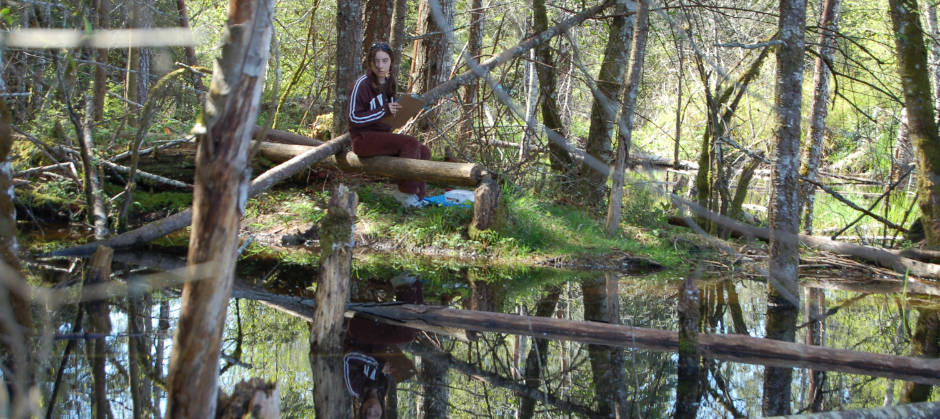 image of girl in park sitting on log